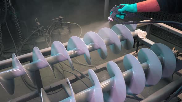 Application of white anti-corrosion powder coating to metal industrial rotors with stray gun in a pl alt