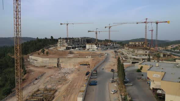 Aerial fly up shot over resident building construction site with standing cranes, Israel Jerusalem a alt