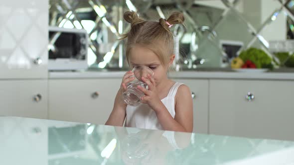 Drink Water. Small Girl Drinking Water From Glass At Kitchen