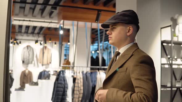 Young Confident Man in Luxury Menswear Boutique Trying on New Suit. Men's Clothing Store alt