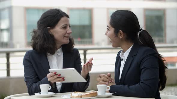 Businesswomen Using Tablet Pc in Outdoor Cafe alt