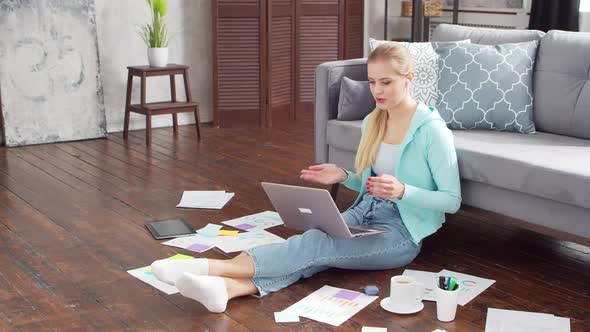 Young woman works with documents using a laptop at home. alt