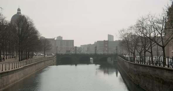 River Spree floats trough a bridge in Berlin with the City of Berlin in the background alt