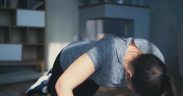 Woman with Ponytail Does Push Ups Standing on Knees in Room