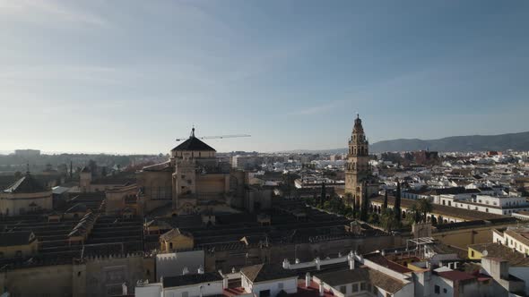 Aerial orbiting over Cordoba Cathedral and Bell tower with Cityscape as background. Spain