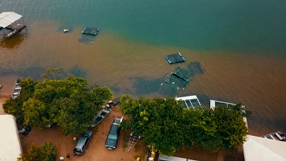 Bird's eye drone view flying over a fish farm on the shore of a lake in the Tocantins region of Braz alt