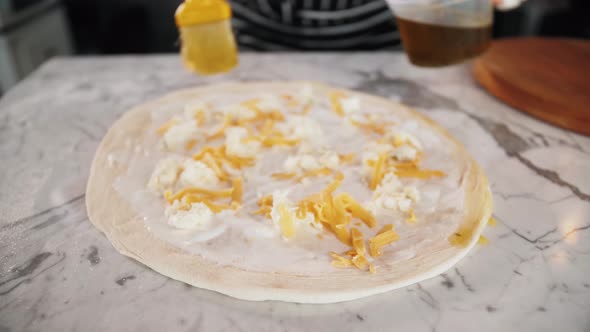 Chef Spreading Sour Cream and Cheese Over Pizza Dough Cooking Italian Pizza alt