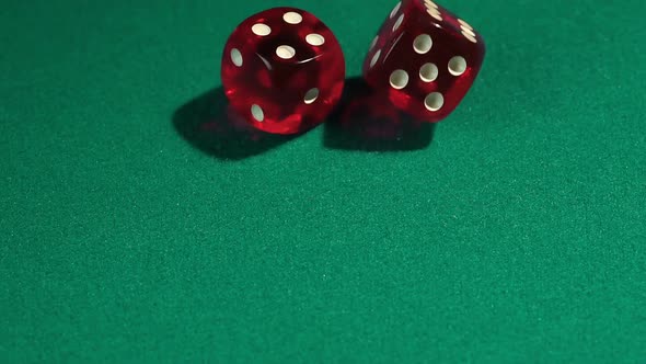Macro view of red dice falling on green table, playing game at the Vegas casino alt