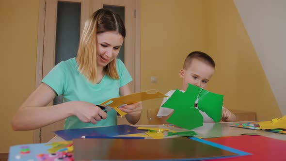 Mother Spending Time with Son Making Application Child Cutting Colored Paper alt