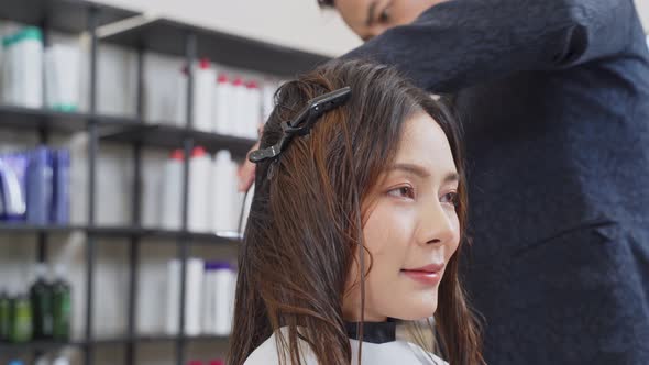 Attractive Asian beautiful woman changes her hair style by professional hairdresser at beauty salon. alt