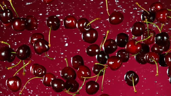 Super Slow Motion Shot of Flying Fresh Cherries and Water Side Splash on at 1000Fps. alt