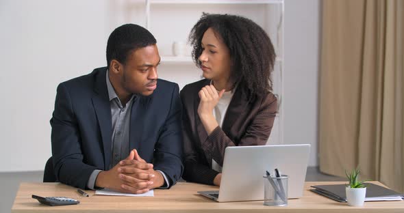 Two Afro American Men Sitting at Table in Office Businesswoman Telling Secret to Businessman alt