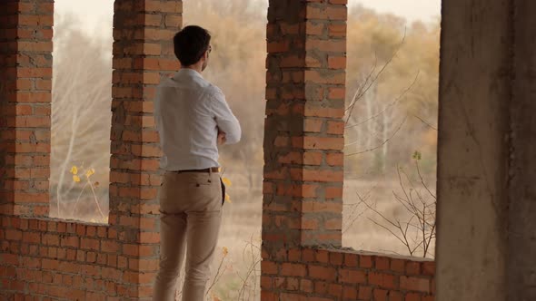Businessman In White Shirt Standing In Unfinished House And Thinking. Man Watching To Horizon. alt