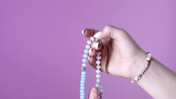 Woman Lit Hand Counts Mala Beads Strands of Gemstones Used for Keeping Count During Mantra alt