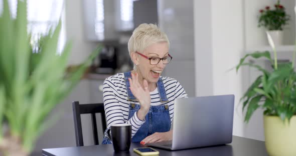 Mature woman making video call from home office