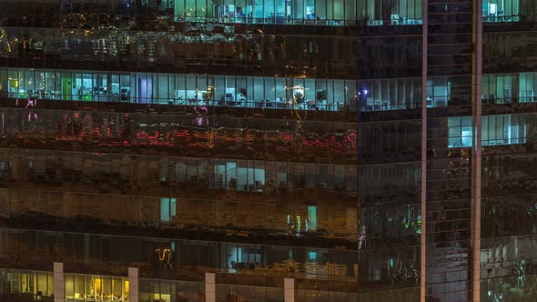 Windows of the Multistorey Building of Glass and Steel Lighting Inside and Moving People Within alt