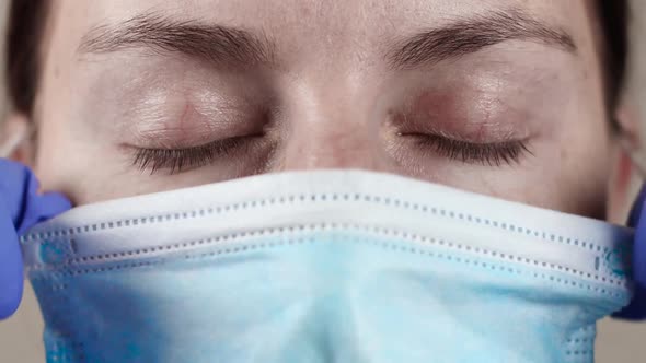 Young Girl Doctor Takes Off Her Protective Medical Mask Close Up alt