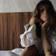 Girl Brunette with Bright Eye Makeup Sits on the Bed in the Hotel Room - VideoHive Item for Sale