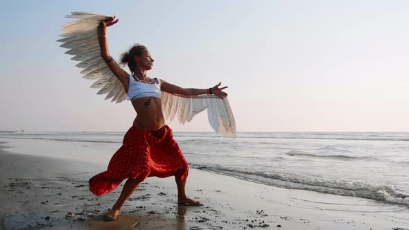 Young Girl with Angel Wings Dancing at Sunset alt