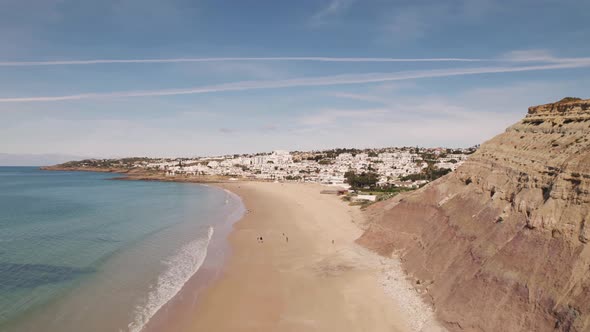 Praia da Luz beach in Algarve.  Empty sandy beach and Atlantic Ocean. Aerial forward alt