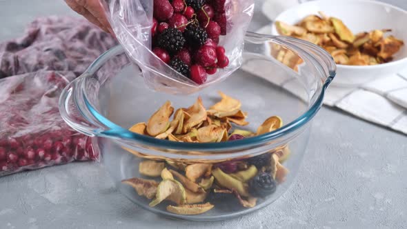 Cooking homemade healthy drink or compote from dried apples and frozen berries