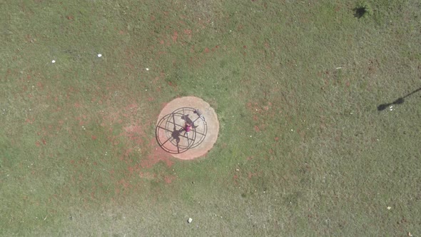 Drone Descending Towards Spinning Wheel in Park