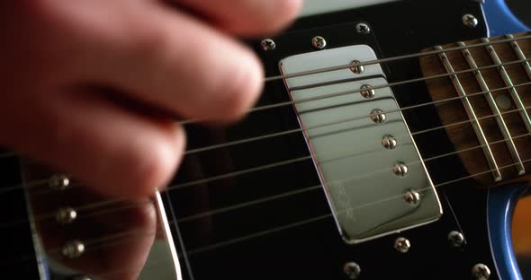 Closeup Guitarist Playing Fingerpicking with a Plectrum on a Electric Guitar