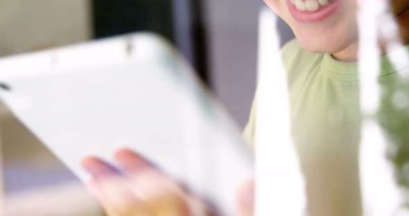 Boy using digital tablet in kitchen alt