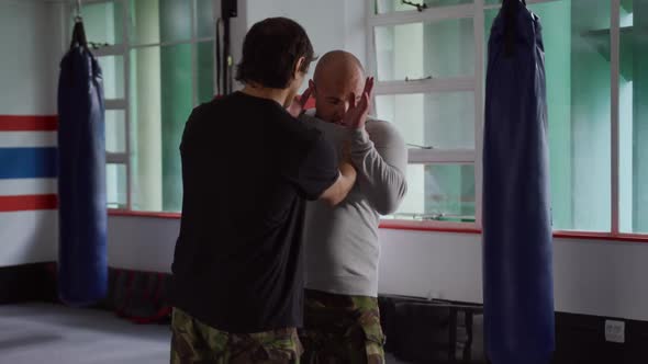 Caucasian coach giving advice in gym alt