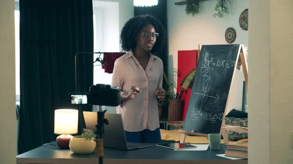 Brown-skinned Teacher Is Giving an Online Lesson From Home During Covid-19 Lockdown alt