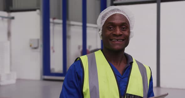 Warehouse worker smiling and looking at camera alt