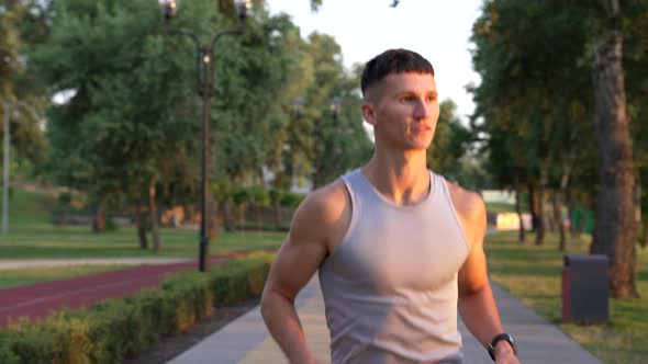 Muscular Man Sprinter Running in the Evening Outdoor Facing Sunset Sport Exercise alt