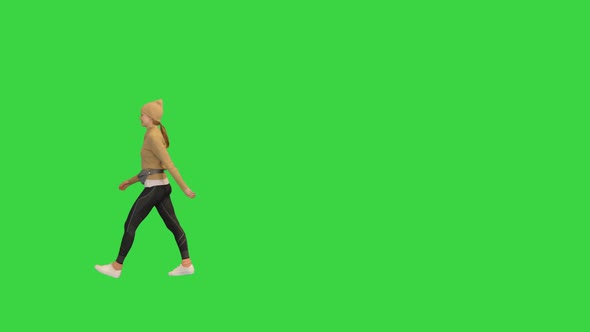 Young Woman in an Trendy Sporty Outfit Walking By on a Green Screen Chroma Key