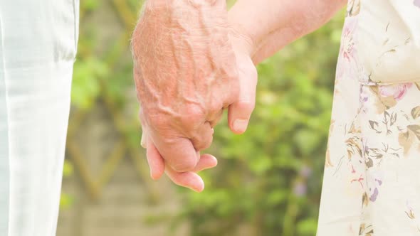 Elderly couple holding hands