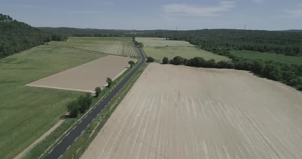 Aerial View of Green Fields and Dry Surrounded By Hills Plants and Mountains alt