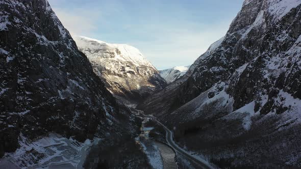 Flying through Naeroydalen valley at morning sunrise - Passing anorthosite mining site close to road alt