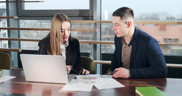 Man and a Woman Discussing Work in the Brightly Lit Modern Office. Concerned Male and Female Working