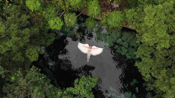Top View of Woman Floating on the Angel Wings at the Cenote Lake in Mexico
