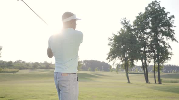 Portrait Handsome Successful Middle Eastern Golfer Swinging and Hitting Golf Ball on Beautiful alt