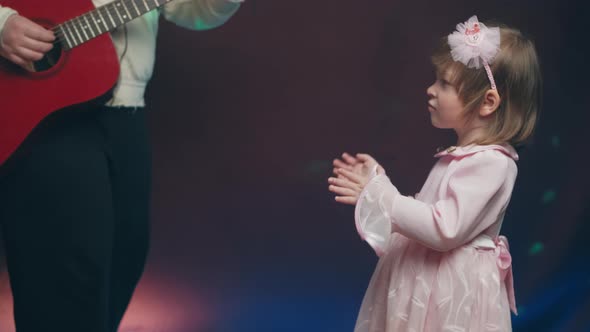 Llittle Girl in Vintage Dress Claps His Hands Her Father Plays Acoustic Guitar