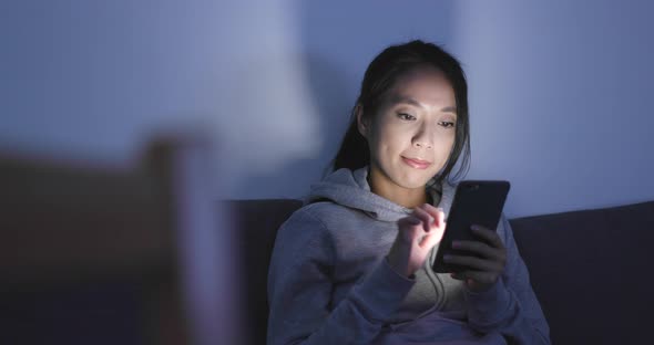 Woman look at smart phone at home alt