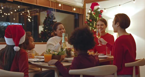 Group of happy diverse mothers and children having dinner celebrating Christmas together