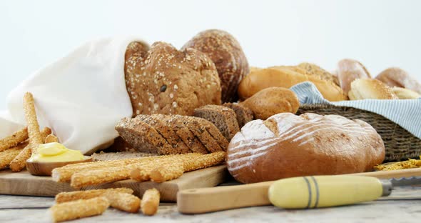 Various bread loaves on wooden table alt