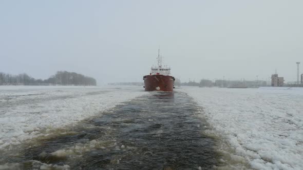 Oil Tanker Moving Through The Ice On Frozen River, Frozen Water, Snow Falling, Oil Tanker Moves Boat