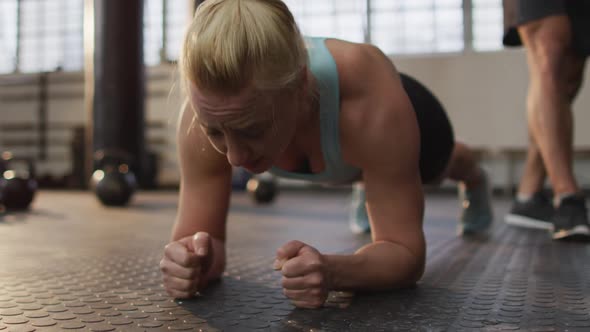 Close up of fit caucasian woman performing plank exercise at the gym alt