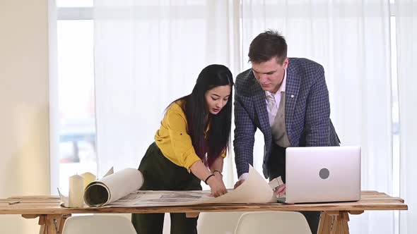 Young employees of design department in roomy bright office discuss project plan alt