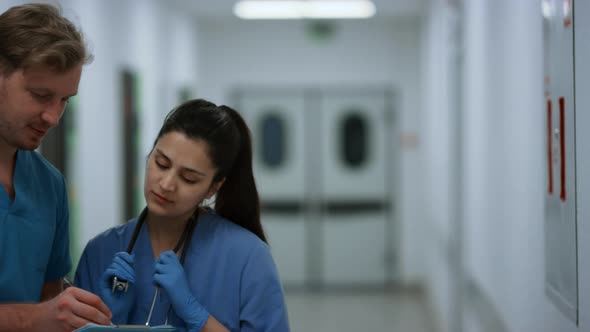 Indian Woman Doctor Consulting Man Surgeon in Hospital Corridor Close Up alt