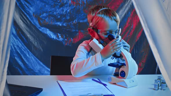 A Little Sientist Virusologist in a Protective Mask on the Invention of a Vaccine a Cure in a alt