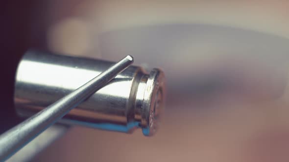 Investigator Takes A Cartridge By Dint Of A Tweezers And Carefully Examines It