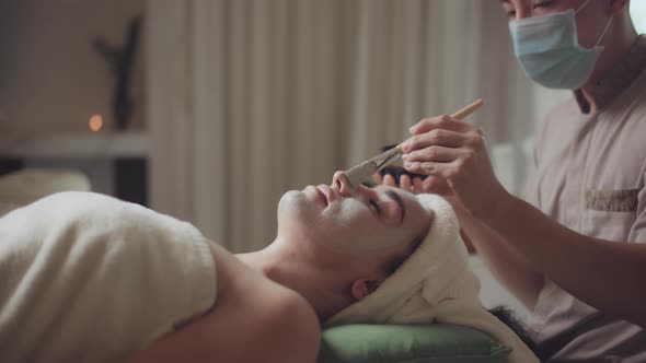Relaxed Woman Lying on Spa Bed for Facial and Head Massage Spa Treatment By Massage Therapist in a alt